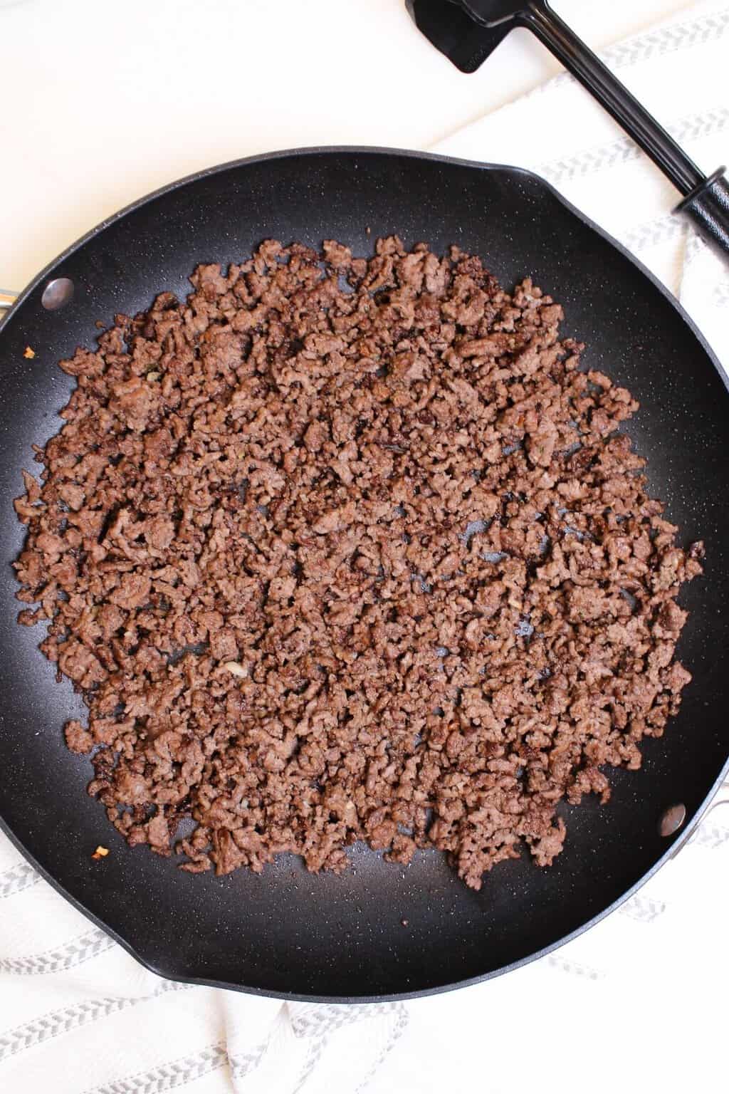Ground beef or lamb being cooked in a skillet.