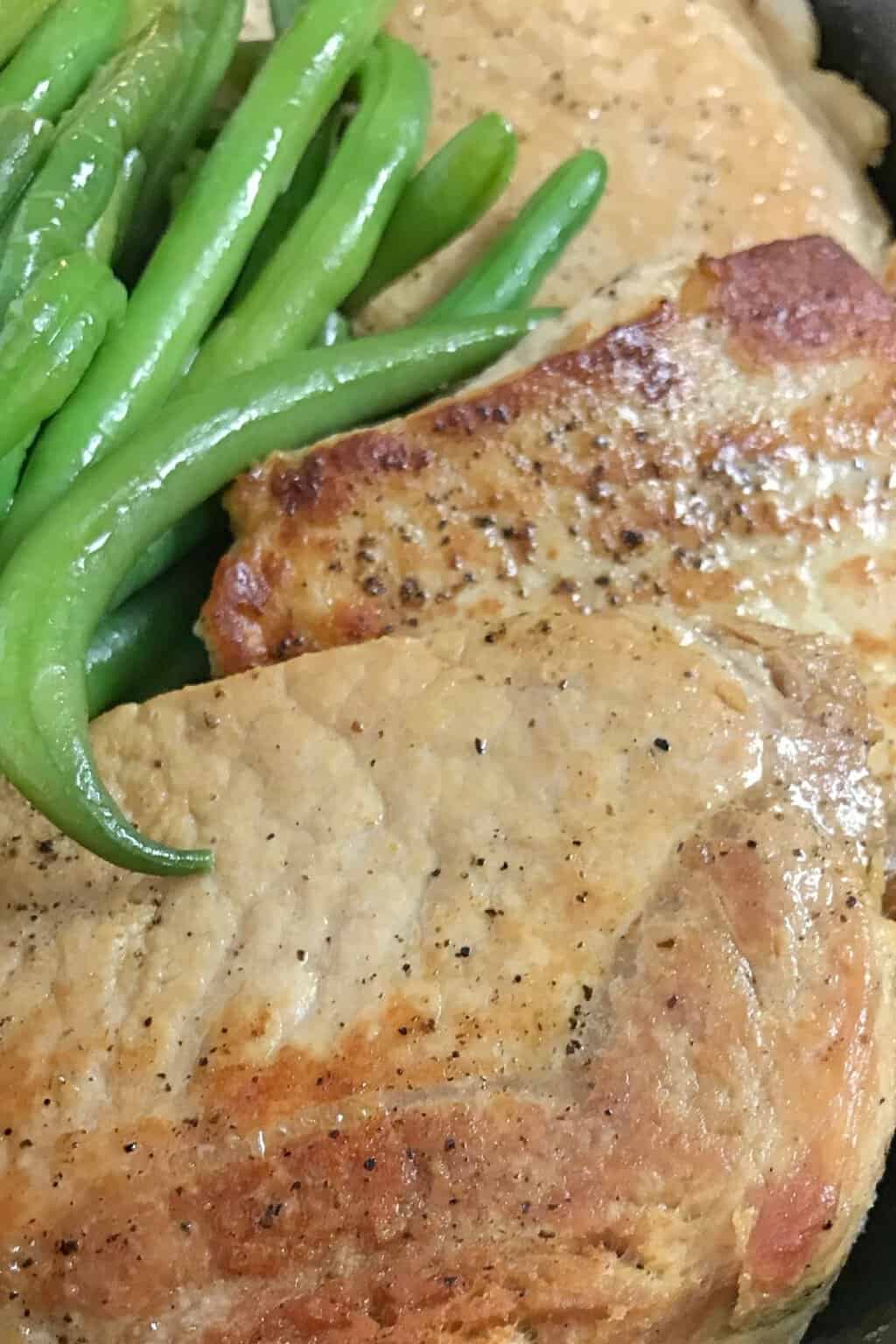 Close up of pork chops and green beans.
