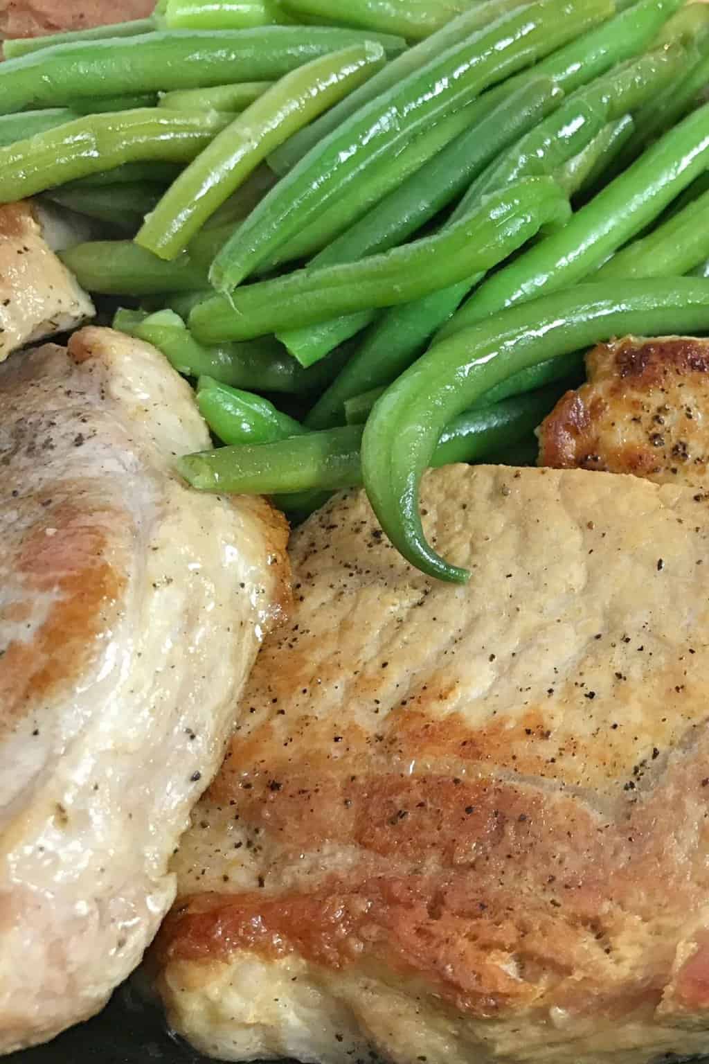 Green beans and cooked pork chops served.