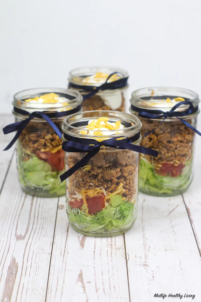 https://www.midlifehealthyliving.com/wp-content/uploads/2021/03/Finished-Taco-Salad-in-a-Jar-Ready-To-Eat.jpg.webp