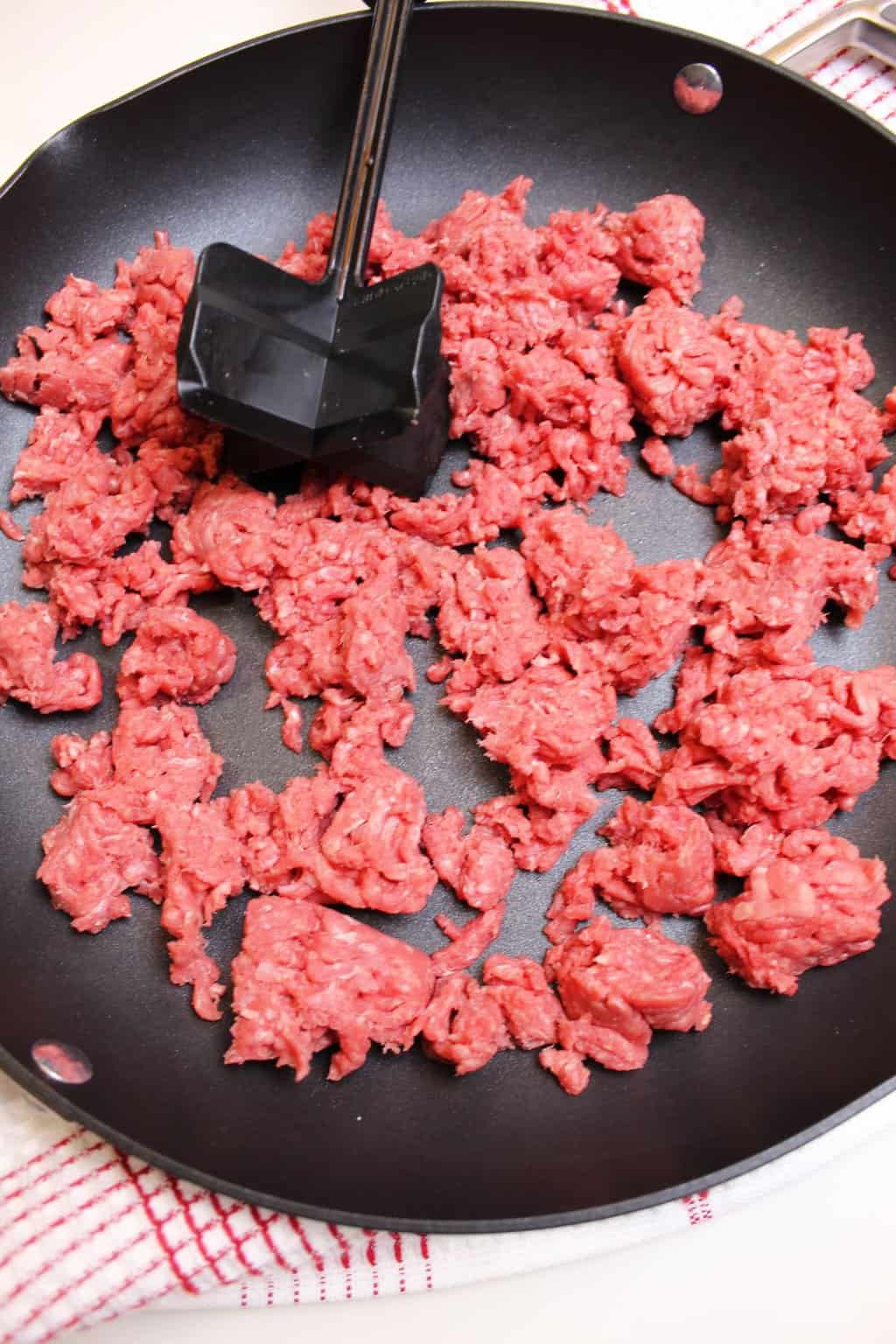 Ground beef cooking on a skillet.