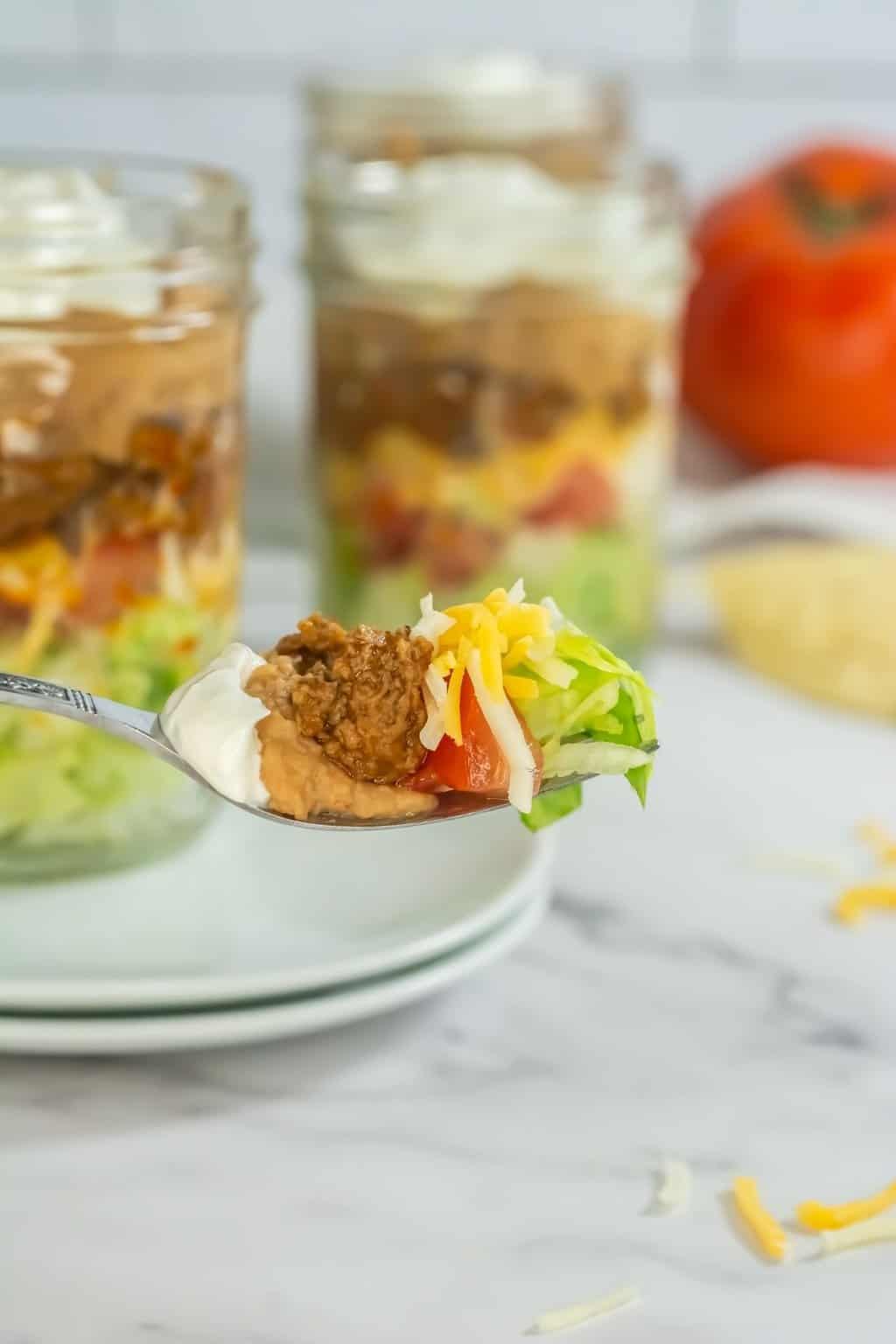 A fork of salad showing off the layers of ingredients.