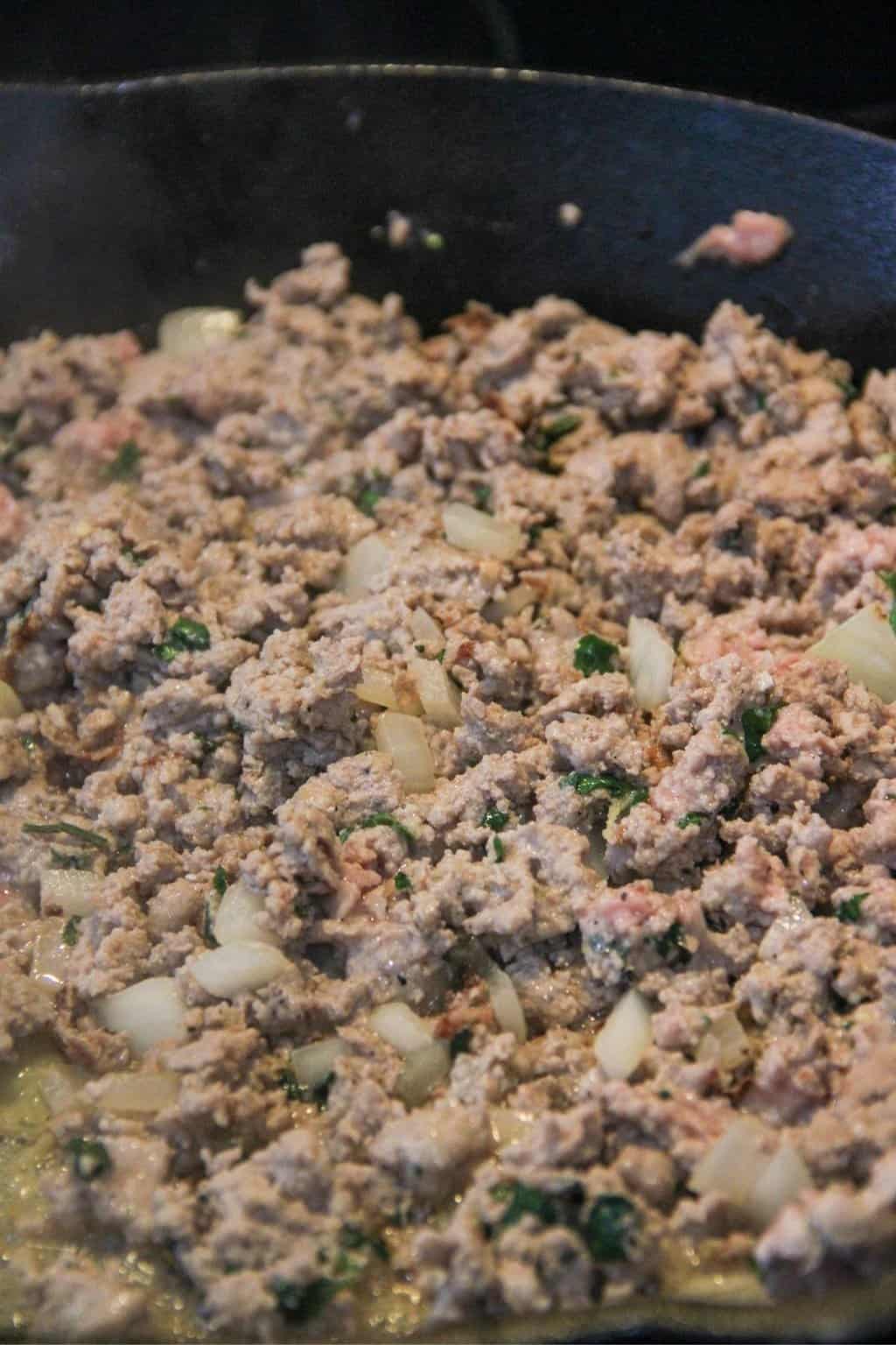 Ground meat cooking on a skillet.