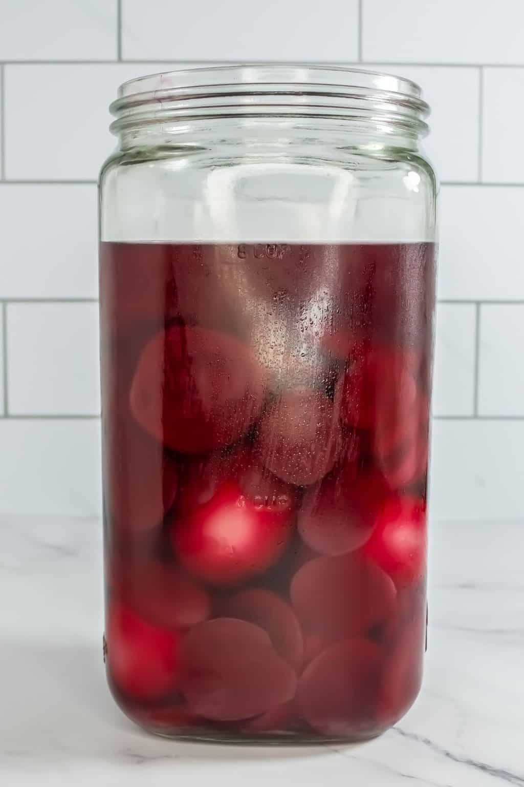 Eggs, beets in a glass jar with liquid.