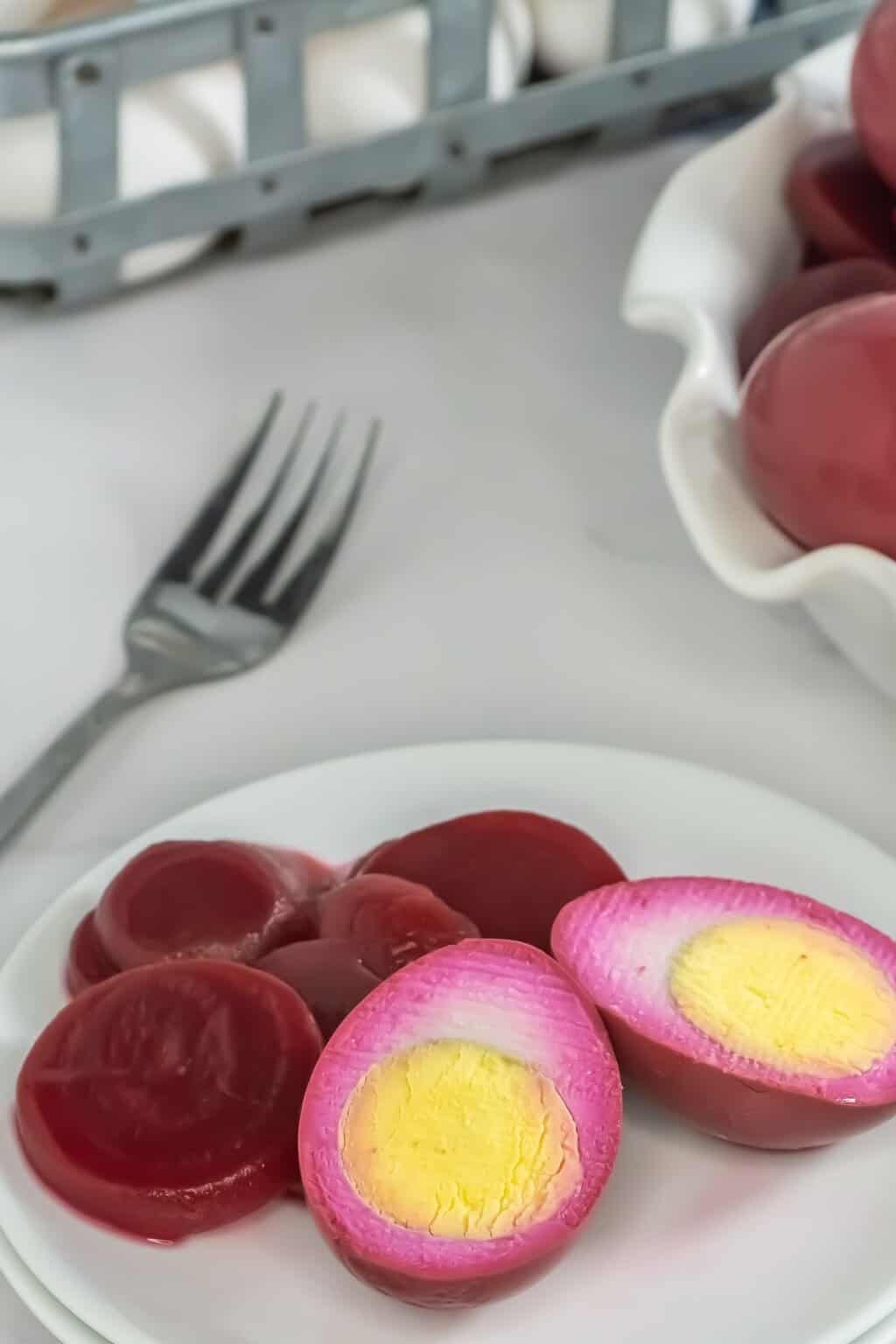 Red eggs served on a white plate, cut in half.