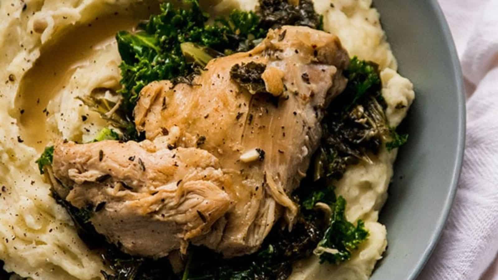 A bowl of mashed potatoes with lemon garlic chicken.