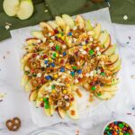 Caramel apple slices served with candies.