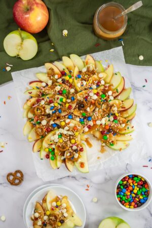 Caramel apple slices served with candies.