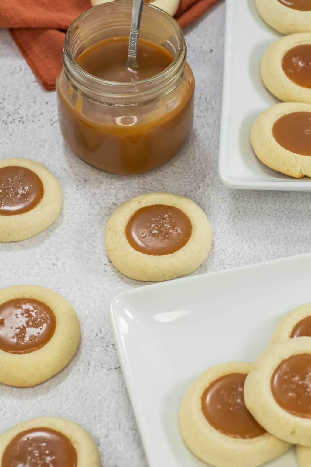 A counter with the cookies and a jar of caramel.