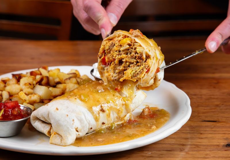 Smothered Breakfast Burrito Packed With Eggs, Beans, And Your Choice Of Meat