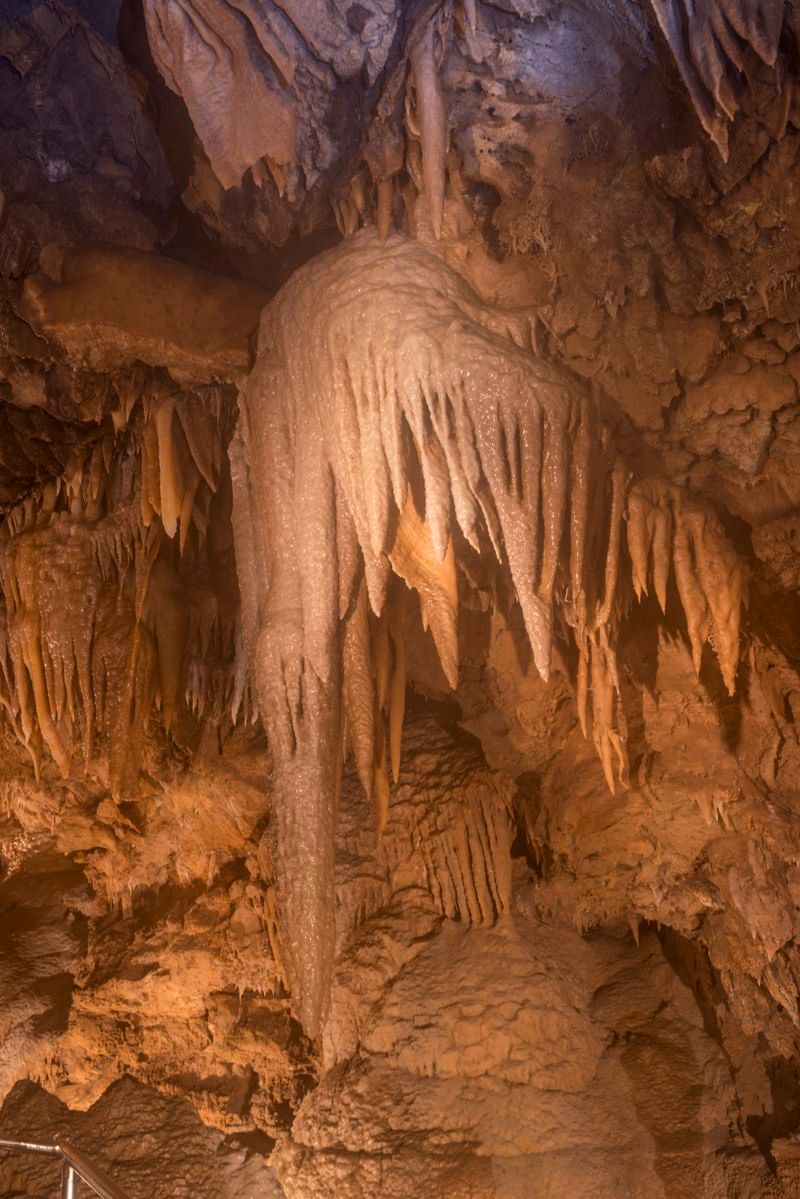 Massive Columns And Flowstone Waterfalls Show The Cave's Slow Sculpted Geology